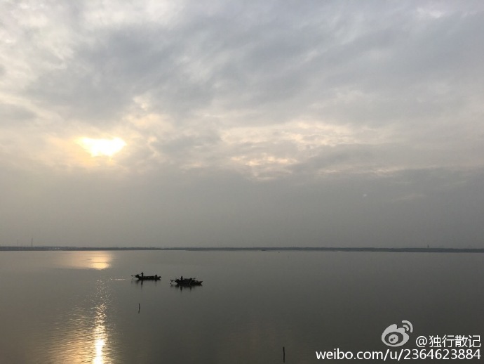 太阳照在阳澄湖上，渔民整理好渔网准备回家.......